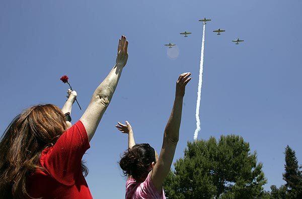 Julietta Corti, left, and Diana Venora cheer during a flyover by the Condor Squad at the Los Angeles National Cemetery. Corti has a brother in Iraq, and Venora has five uncles who served in the military and a grandfather who fought in WW II.