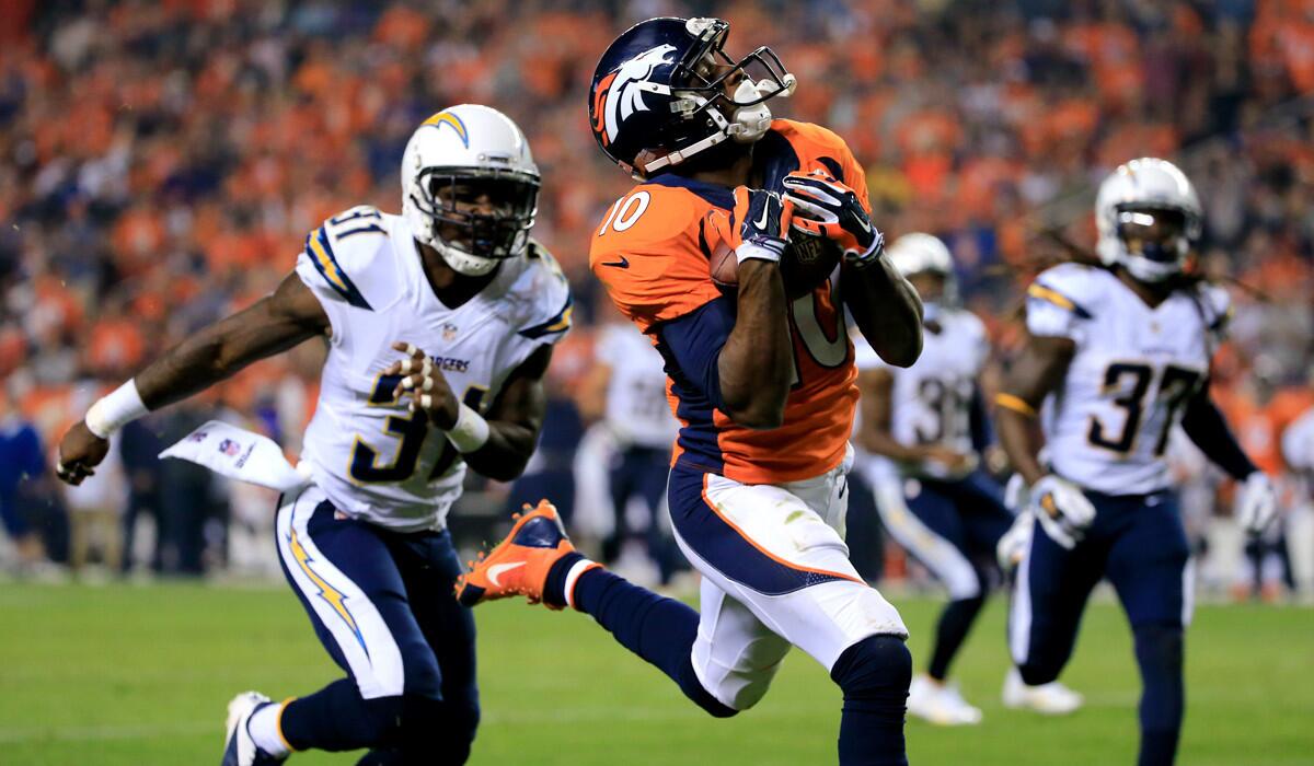 Broncos wide receiver Emmanuel Sanders gathers a 31-yard touchdown pass against the Cahrgers in the second quarter Thursday night in Denver.