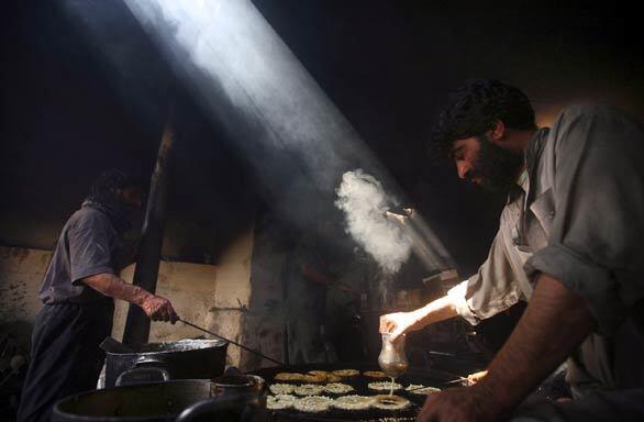 Afghan men make fried sweets known as jalebi at a shop in Kabul.