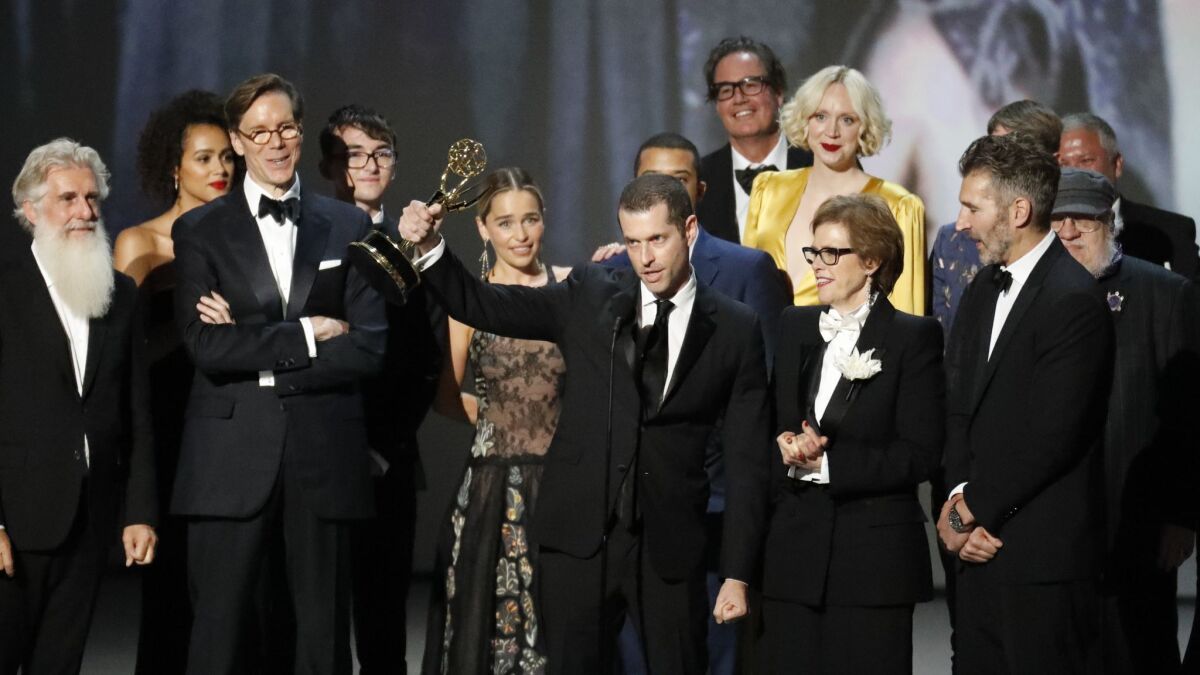 "Game of Thrones" producer and co-creator D.B. Weiss holds up the Emmy awarded to "Game of Thrones" for outstanding drama series on Monday in Los Angeles. Co-executive producer Guymon Casady is standing in the back behind Weiss and actress Gwendoline Christie in the yellow gown.