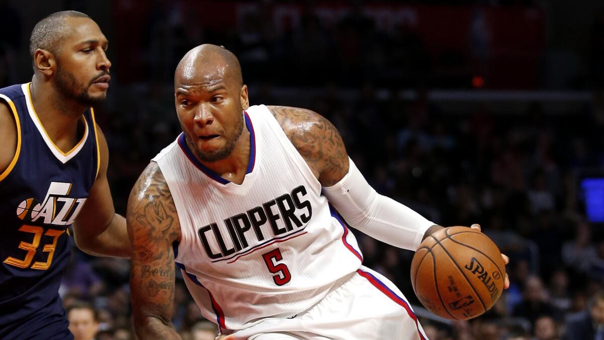 Clippers forward Marreese Speights drives to the basket against Jazz forward Boris Diaw during the second half Saturday. (Danny Moloshok / Associated Press)