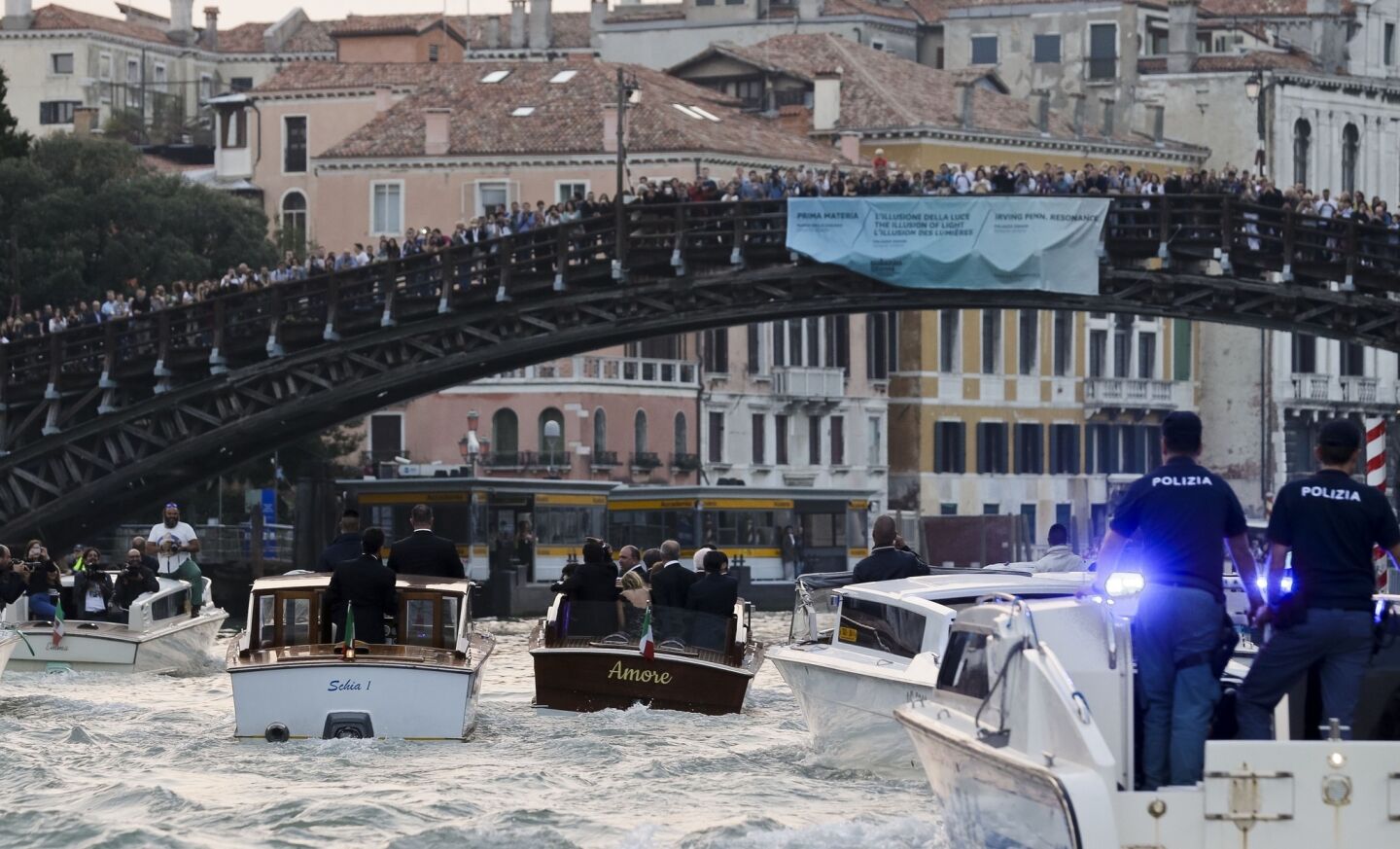 Fans crowd the Academia Bridge on Venice's Grand Canal to catch a glimpse of a tuxedo-clad George Clooney in the Amore on his way to marry Amal Alamuddin.