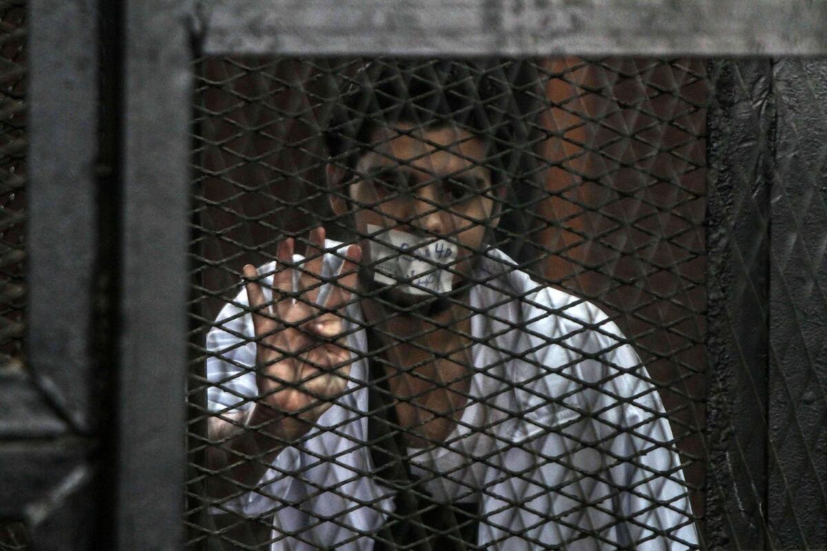 A defendent stands in the prisoners dock during the trial of 20 people on terror-related charges in Cairo.