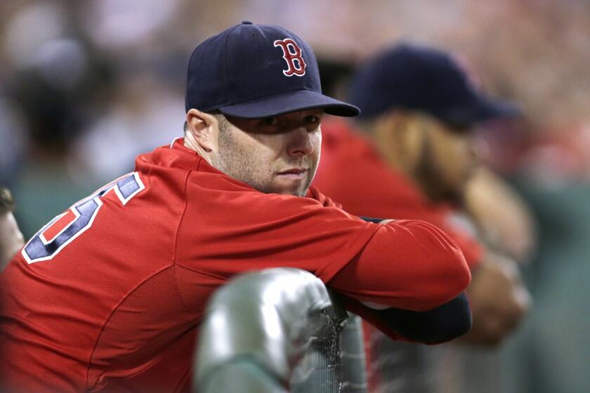Boston Red Sox second baseman Dustin Pedroia watches from the dugout rail Friday at Fenway Park.