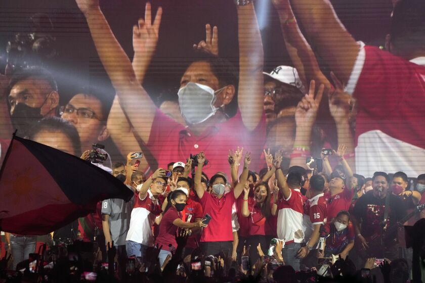 Presidential hopeful, former senator Ferdinand "Bongbong" Marcos Jr., center, the son of the late dictator, greets the crowd during a campaign rally in Quezon City, Philippines on Wednesday, April 13, 2022. Campaigning in the Philippines' presidential election continues with a cast of candidates led by a late dictator's son and the pro-democracy current vice president, with all vowing to bail out a country driven deeper into poverty by the pandemic and plagued by gaping inequalities and decades-long insurgencies. (AP Photo/Aaron Favila)
