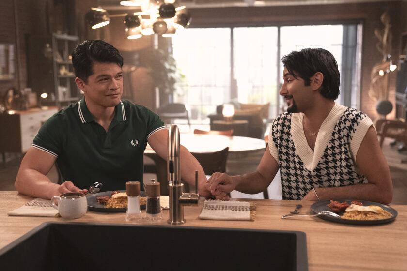 Two man hold hands and smile over a romantic breakfast