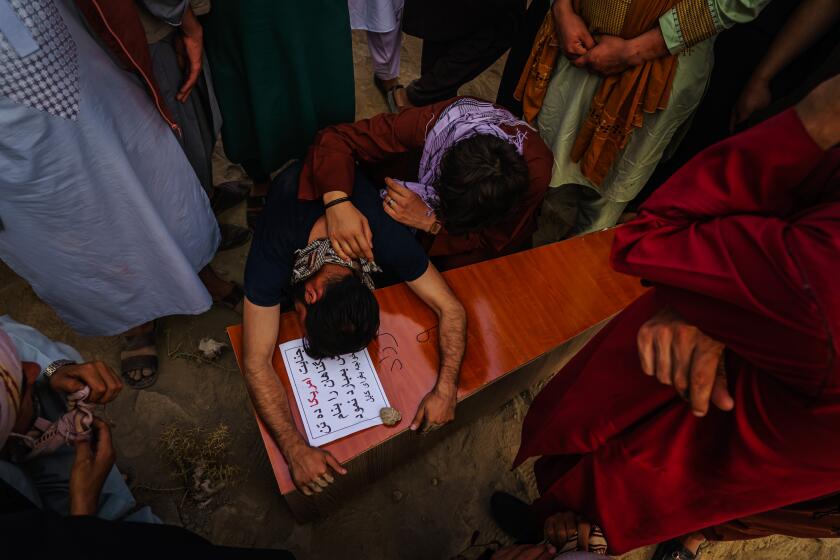 KABUL, AFGHANISTAN -- AUGUST 30, 2021: A relative throws himself and weeps over the casket of Farzad, 12, who was killed by U.S. drone airstrikes, according to the family, in Kabul, Afghanistan, Monday, Aug. 30, 2021. (MARCUS YAM / LOS ANGELES TIMES)