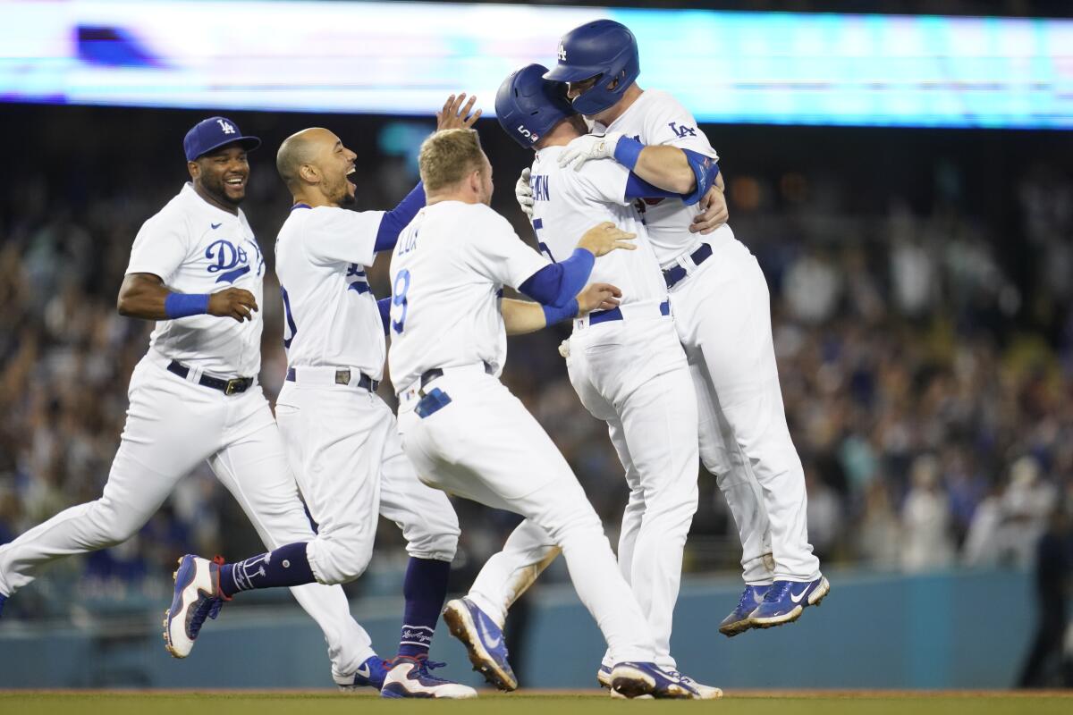 The Dodgers celebrate after beating the Cubs 4-3 on a 10th-inning, walk-off single by Will Smith, right, on July 8, 2022.