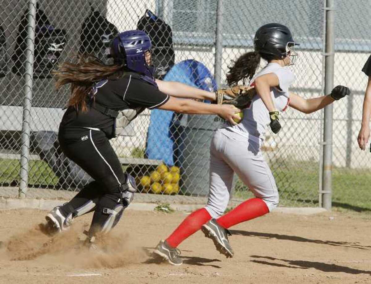 Hoover's catcher Jenesy Gonzalez, left, tags Glendale's Alex Howard in a Pacific League softball game the Nitros won, 11-5.