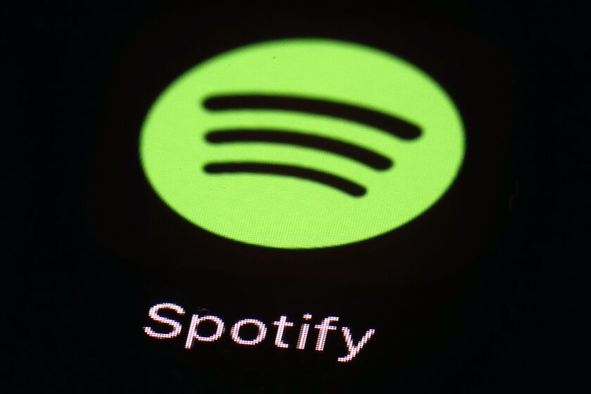 FILE- This March 20, 2018 file photo shows the Spotify app on an iPad in Baltimore. Spotify is cutting about 200 people, or 2% of its workforce, as the streaming company reworks its podcast unit. Sahar Elhabashi, vice president, Head of Podcast Business, said in a memo that impacted employees would receive severance packages including extended health care coverage and immediate access to outplacement support. (AP Photo/Patrick Semansky, File)