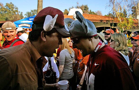 John Hay, left, of Austin, Texas, and Stephen Woirol, of Yorktown, Va., playfully butt heads as they show their alliances outside the Rose Bowl before the start of the BCS Championship Game at the Rose Bowl in Pasadena.