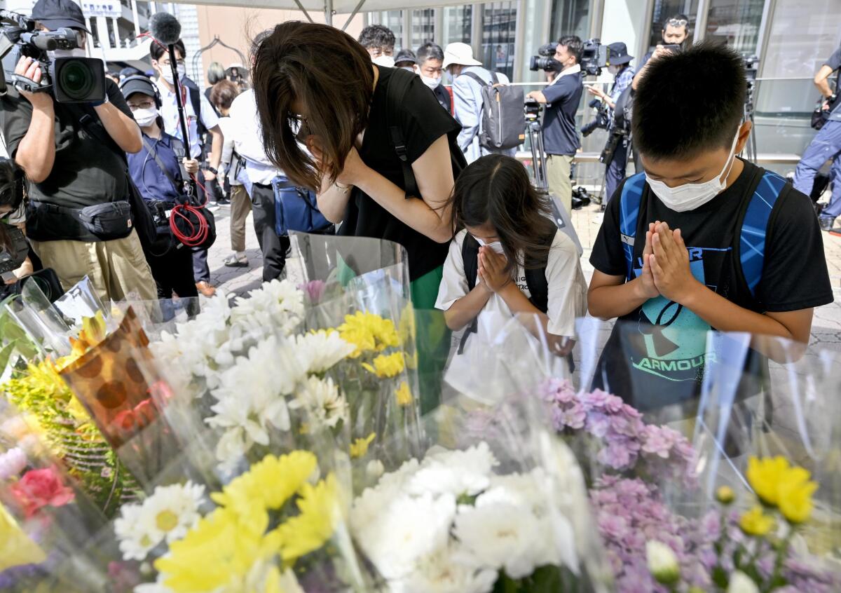 Gente rezando en un altar improvisado cerca del lugar donde el ex primer ministro de Japón Shinzo Abe murió baleado