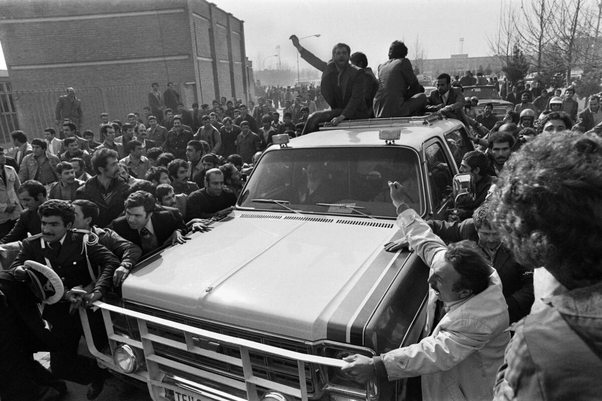 Multitudes gather in Tehran to cheer the motorcade carrying Iranian opposition leader and founder of Iran's Islamic republic Ayatollah Ruhollah Khomeini upon his return from exile on Feb. 1, 1979.