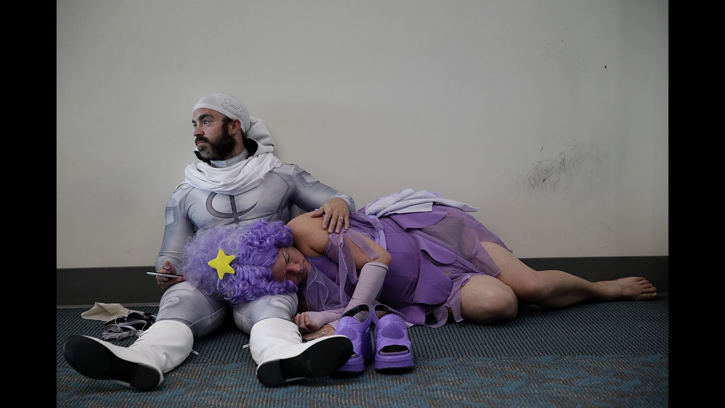 Derek Shackleton acts as a pillow for Faeran Adams, who naps after a long day of cosplaying as Lumpy Space Princess from the "Adventure Time" cartoon at Comic-Con 2016. Shackleton is dressed as Marvel comics' Moon Knight.