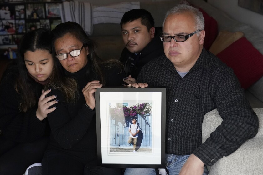 Cassandra Quinto-Collins, second from left, holds a photo of her son, Angelo Quinto, while sitting with daughter Bella Collins, left, son Andrei Quinto, center, and husband Robert Collins during an interview in Antioch, Calif., Tuesday, March 16, 2021. Angelo Quinto died three days after being restrained on Dec. 23, 2020, in police custody while having a mental health crisis. Lawmakers in several states are proposing legislation that would require more training for police in how to interact with someone in a mental crisis following some high-profile deaths. (AP Photo/Jeff Chiu)