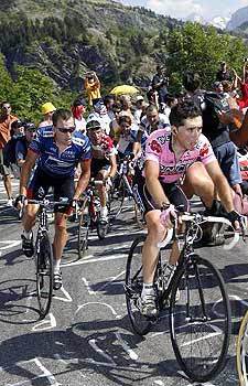 Joseba Beloki of Spain, right, climbs the final miles to L'Alpe d'Huez as Lance Armstrong of the United States follows during the Tour de France. Armstrong took the overall leader's yellow jersey in the stage.