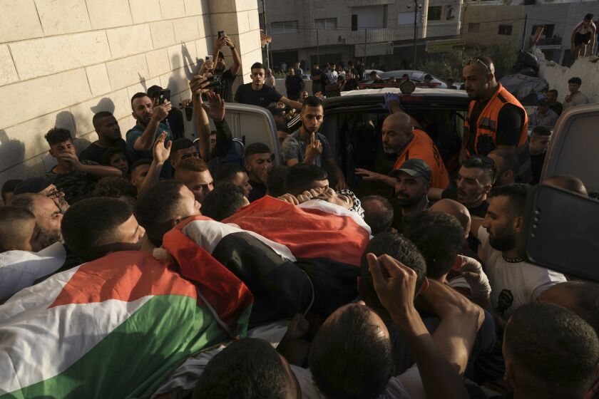 Palestinian mourners carry the body of Fayez Damdoum in the West Bank village of Azariyah, Saturday, Oct. 1, 2022. Israel's paramilitary border police said forces shot a protester who attempted to throw a firebomb at them as they came to disperse a demonstration. It said demonstrators threw stones and explosives at them. The Palestinian Health Ministry identified the dead youth as 18-year-old Fayez Damdoum. (AP Photo/Mahmoud Illean)