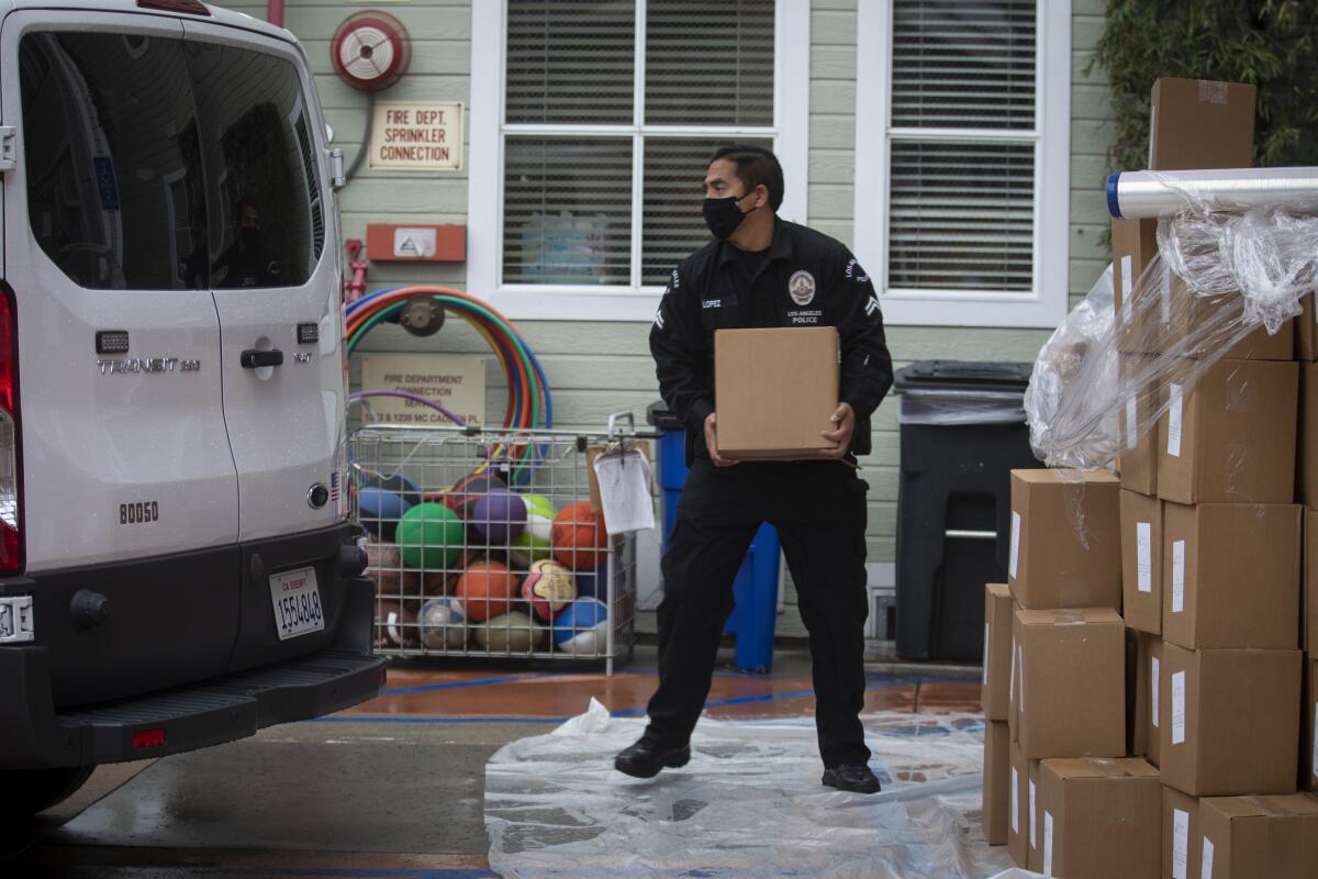 LAPD Officer Anthony Lopez transfers supplies to be delivered to home-bound seniors in Hollywood on Thursday.