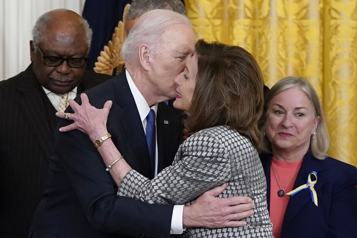 President Joe Biden kisses House Speaker Nancy Pelosi during an event in the East Room of the White House, April 5, 2022. 