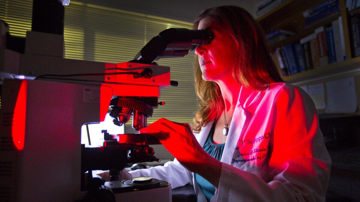 Dr. Julie Steele, division head of anatomic pathology at Scripps Clinic and Scripps Green Hospital in La Jolla, examines breast tissue for signs of cancer.