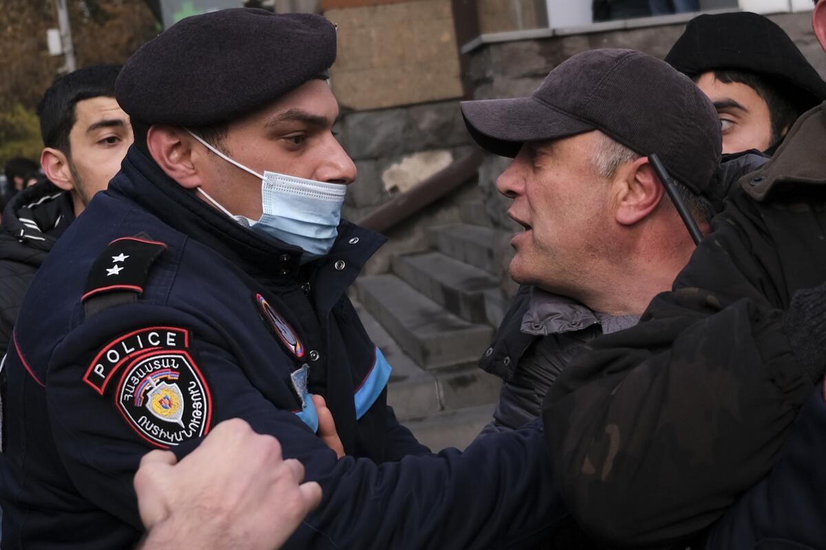 A police officer confronts a demonstrator during a protest in Yerevan, Armenia.