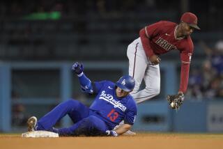 Los Angeles Dodgers' Max Muncy (13) reaches second on a double ahead of a throw to Arizona Diamondbacks shortstop Geraldo Perdomo, right, during the fourth inning of a baseball game against the Arizona Diamondbacks in Los Angeles, Thursday, Sept. 22, 2022. Will Smith scored. (AP Photo/Ashley Landis)