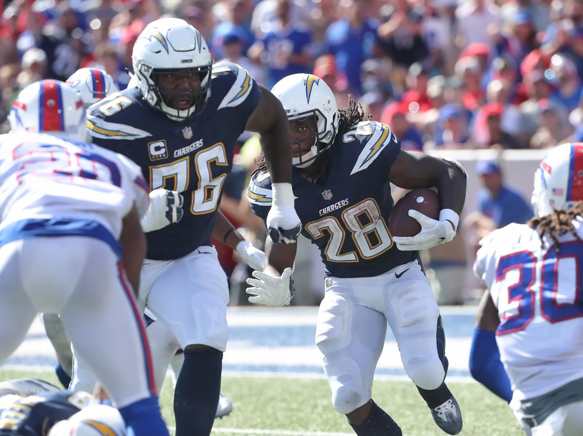Chargers tackle Russell Okung (76) leads the way for running back Melvin Gordon during a game last season.