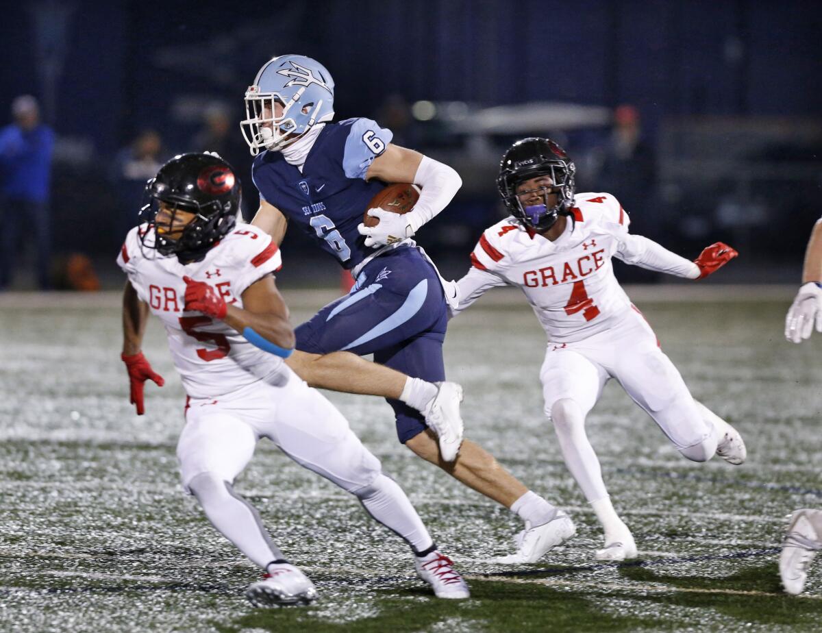 Corona del Mar’s John Humphreys (6) runs after the catch against Grace Brethren’s George Bowers IV (4) and Julien Stokes in the CIF Southern Section Division 3 title game on Nov. 29 at Newport Harbor High.