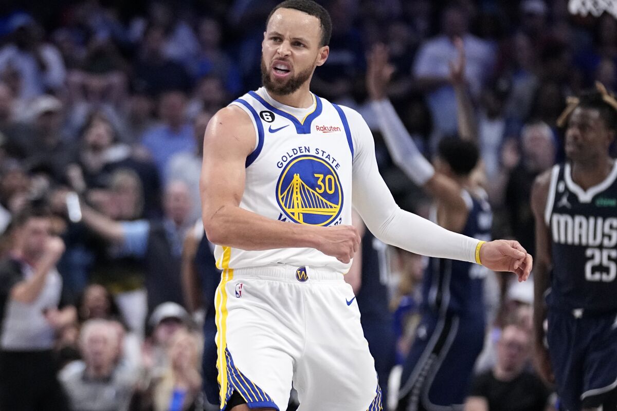 Golden State Warriors guard Stephen Curry celebrates a basket against the Dallas Mavericks in the second half of an NBA basketball game, Wednesday, March 22, 2023, in Dallas. (AP Photo/Tony Gutierrez)