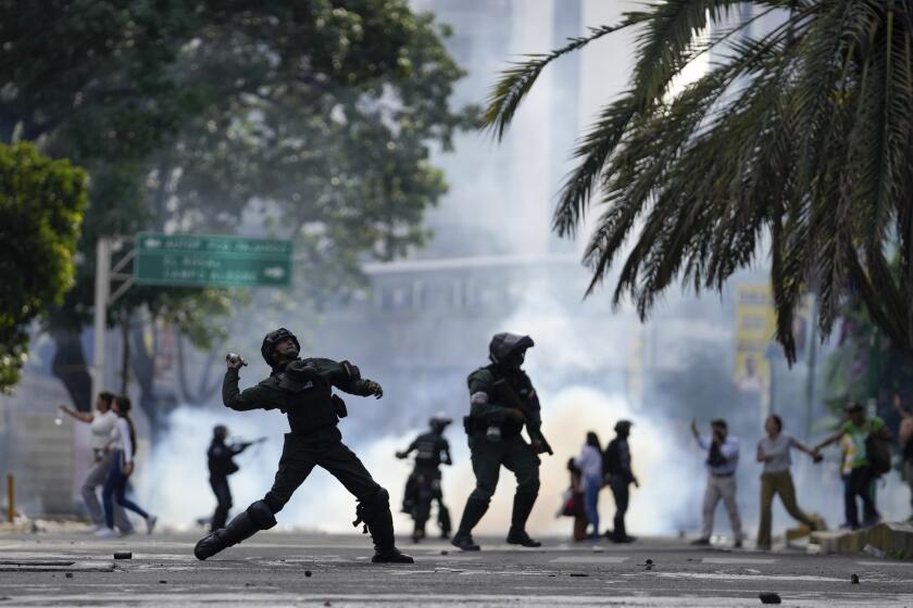 Police hurdle a gas canister at protesters demonstrating against the official election results declaring President Nicolas Maduro's reelection, the day after the vote in Caracas Venezuela, Monday, July 29, 2024. (AP Photo/Matias Delacroix)