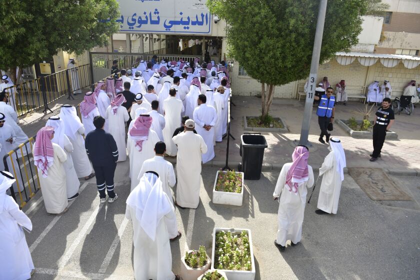 People stand in line to cast their votes in National Assembly elections at a religious school in Sabahiya district, Kuwait, Tuesday, June 6, 2023. Voters in Kuwait were casting ballots on Tuesday for a third time in as many years, with little hope of ending a prolonged gridlock between the ruling family and assertive lawmakers after the judiciary dissolved the legislature earlier this year. (AP Photo/Jaber Abdulkhaleg)