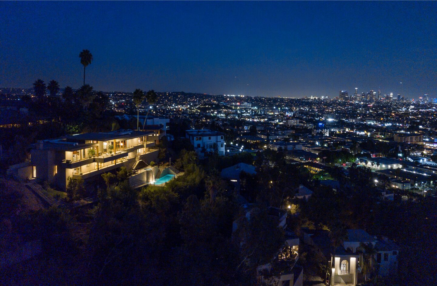 The hillside home at night.