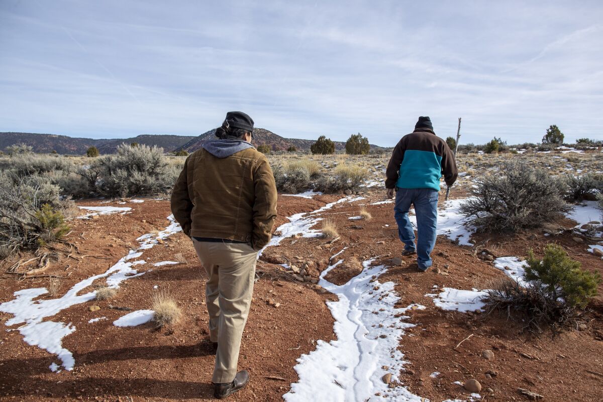 Jonah Yellowman, right, and his friend Angelo Baca cross Cedar Mesa after procuring a hot coal poker — honeeshgish in Navajo — from a juniper branch.