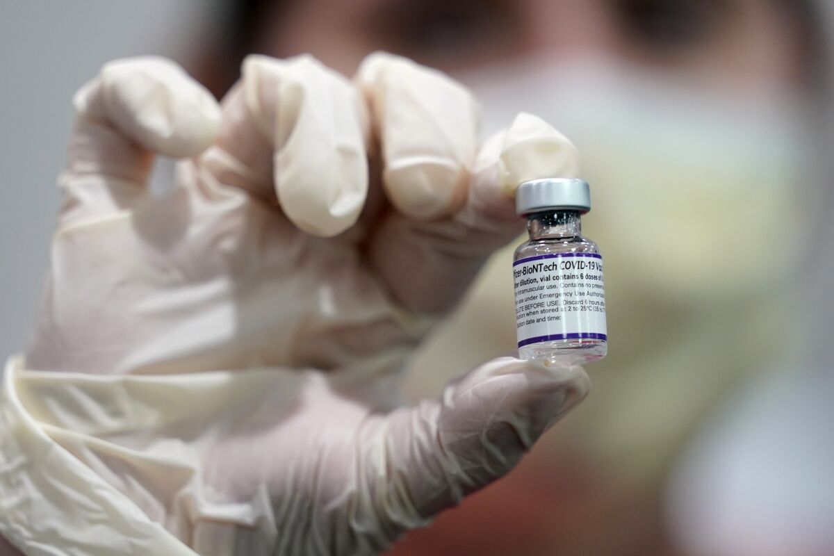 A healthcare worker holds a vial of the Pfizer-BioNTech COVID-19 vaccine 