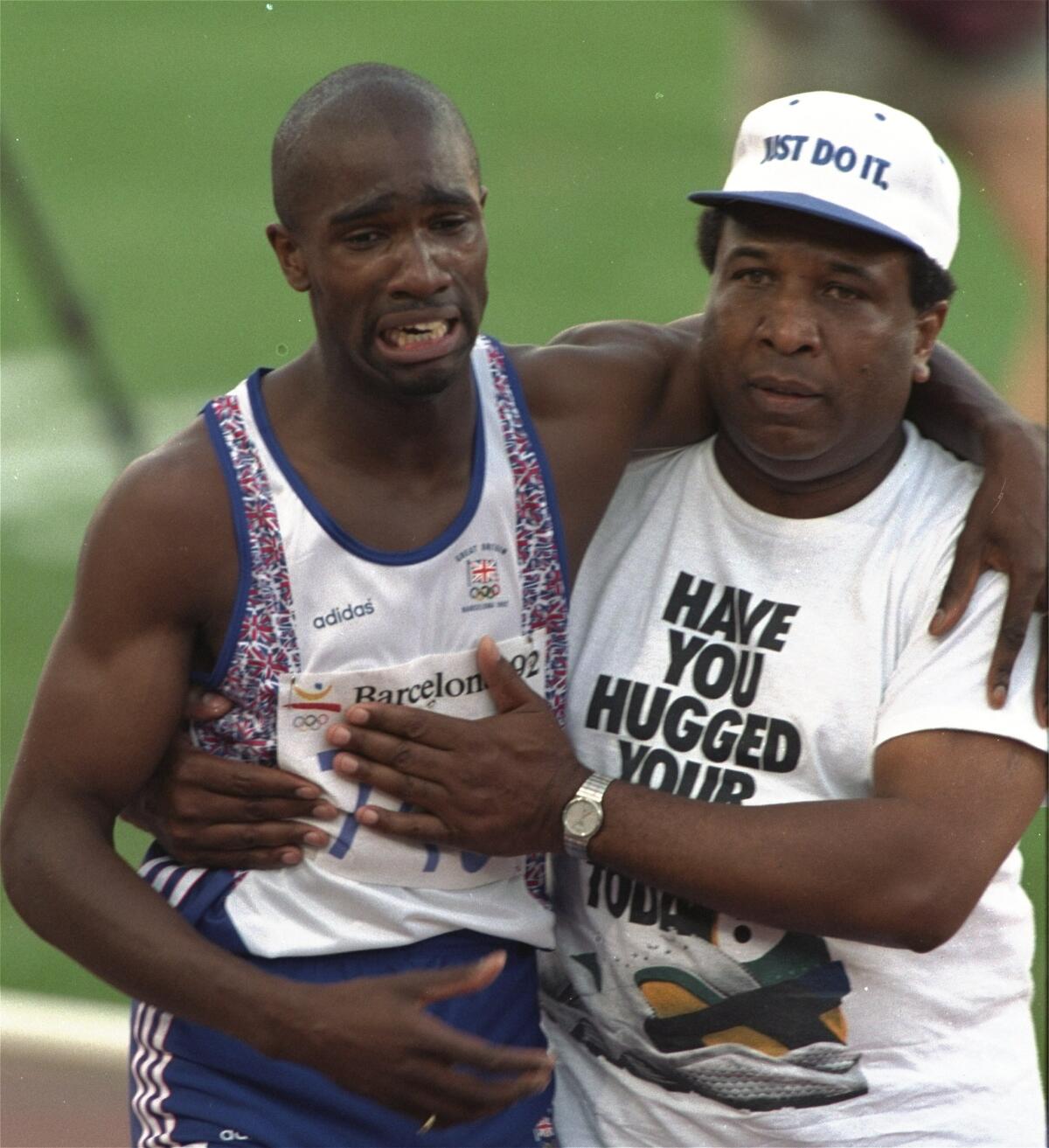 Great Britain's Derek Redmond grimaces as he is helped down the track by his father, Jim, at the 1992 Olympics.