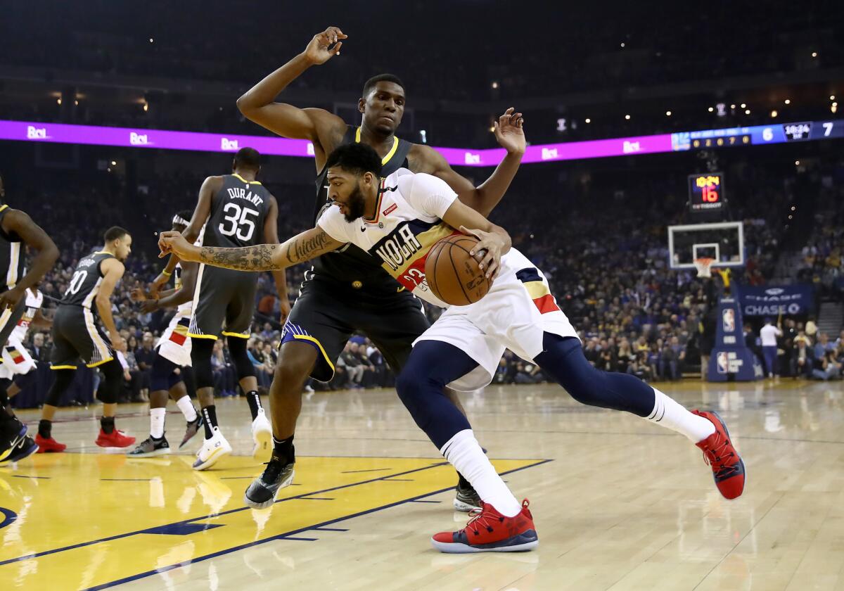 Anthony Davis #23 of the New Orleans Pelicans drives on Kevon Looney #5 of the Golden State Warriors at ORACLE Arena on January 16, 2019 in Oakland, California.