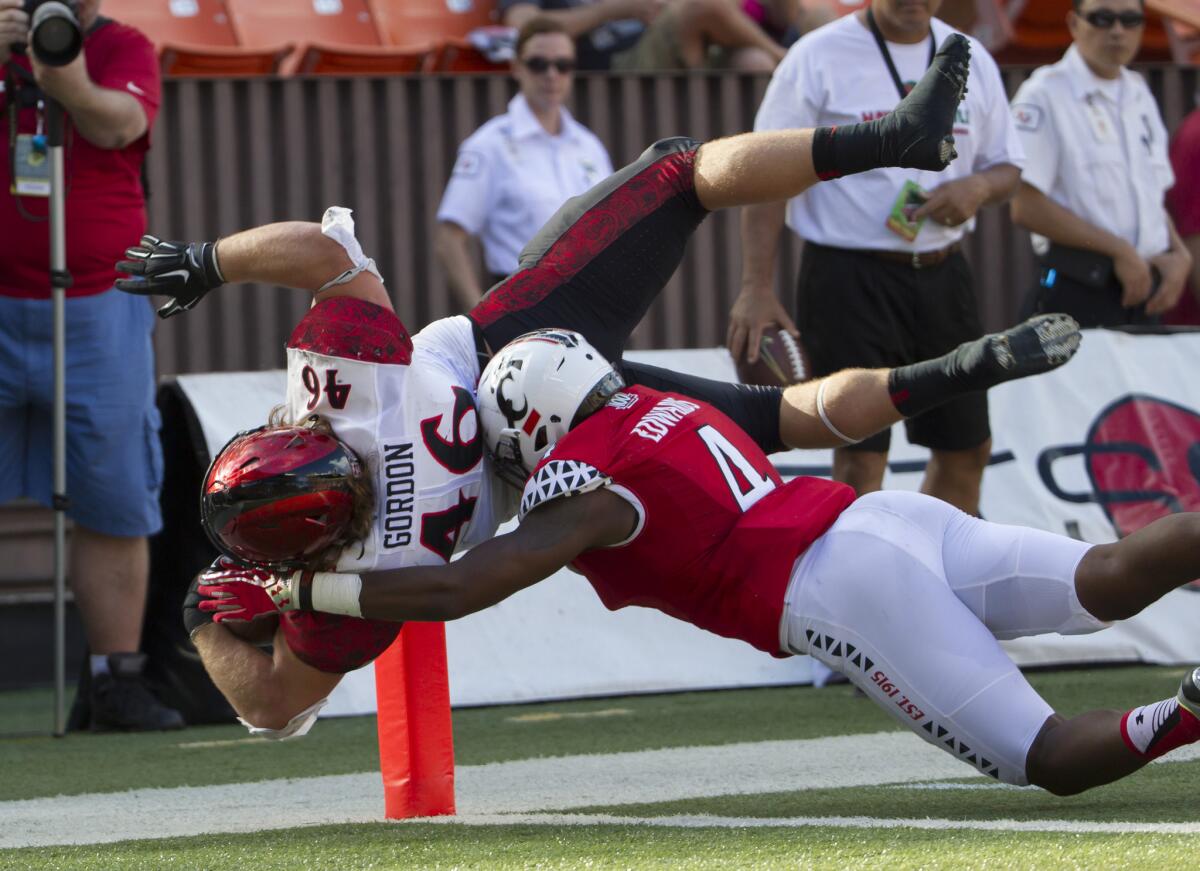 San Diego State running back Dakota Gordon (46) dives into the end zone for a touchdown while getting hit by Cincinnati safety Zach Edwards (4) in the second quarter of the Hawaii Bowl.