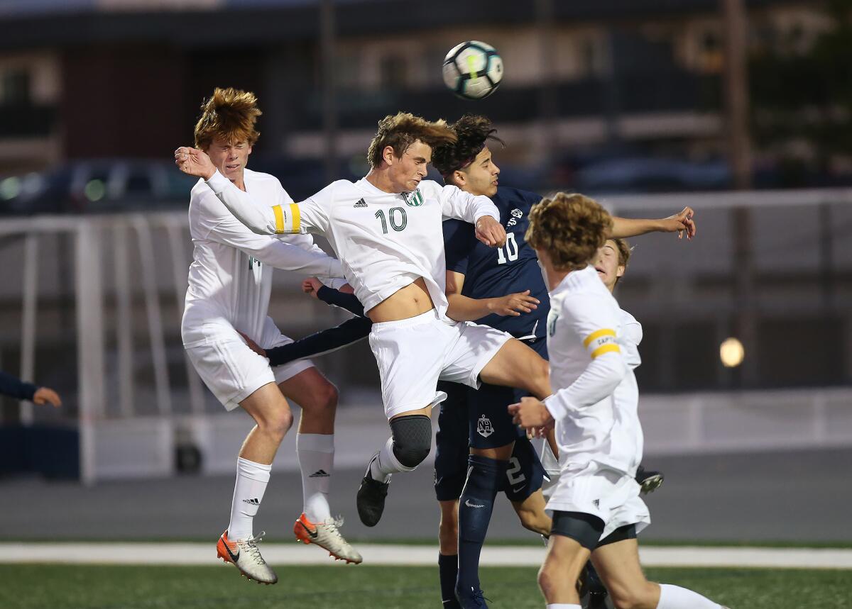 Edison’s Kai Peterson (10) heads the ball before Newport Harbor’s Kevin Soltero (10) can get to it during a Surf League match on Wednesday.