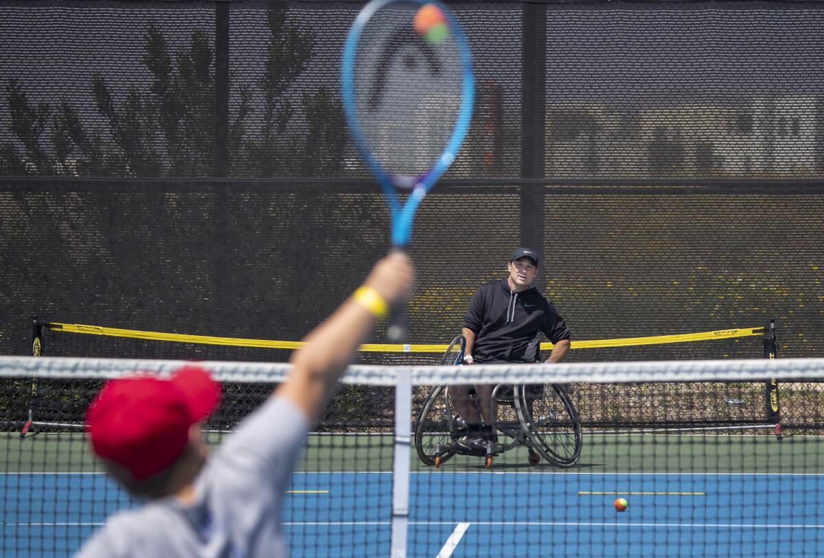 A youth player hits the ball to Paralympian David Wagner during a clinic in Irvine.