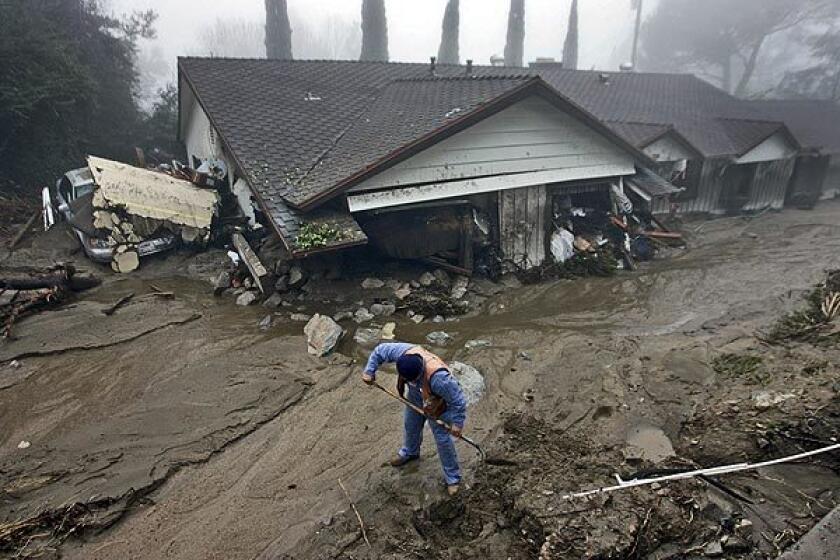 A gas company worker digs in front of a flattened home on Manistee Drive, where the flash flood caused a gas leak.
