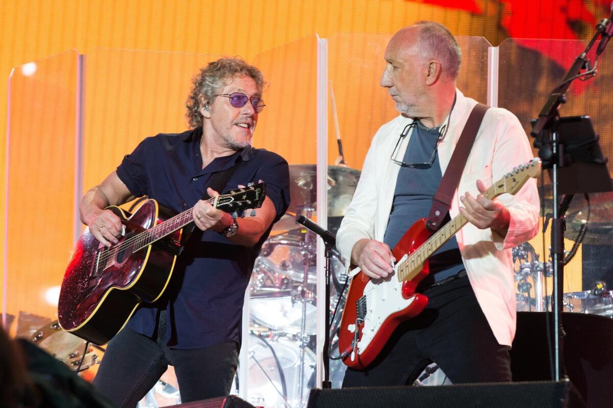 Singer Roger Daltrey, left, and Pete Townshend of the band the Who, shown performing in June at the Glastonbury music festival in England, will resume their 50th anniversary tour in February. Dates had been postponed when Daltrey was diagnosed with viral meningitis.