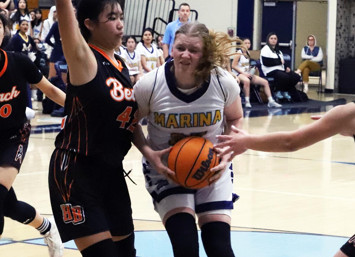 Marina's Sydnie Smith (25) drives to the basket against Huntington Beach on Monday.