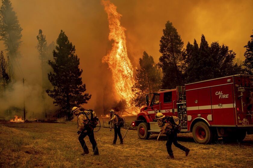 Firefighters work to keep the Oak Fire from reaching a home in the Jerseydale community of Mariposa County, Calif., on Saturday, July 23, 2022. (AP Photo/Noah Berger)