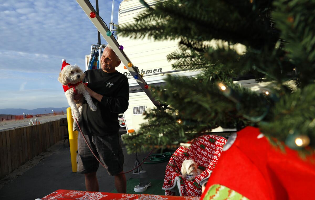 Craig Swanson of Victorville camps with family members, including dogs Penny, left, and Teddy, for the holiday at Dockweiler State Beach.