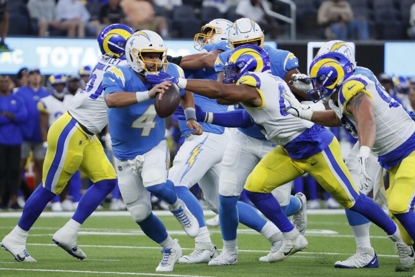 Chargers quarterback Chase Daniel scrambles away from pressure against the Rams on Aug. 13, 2022.