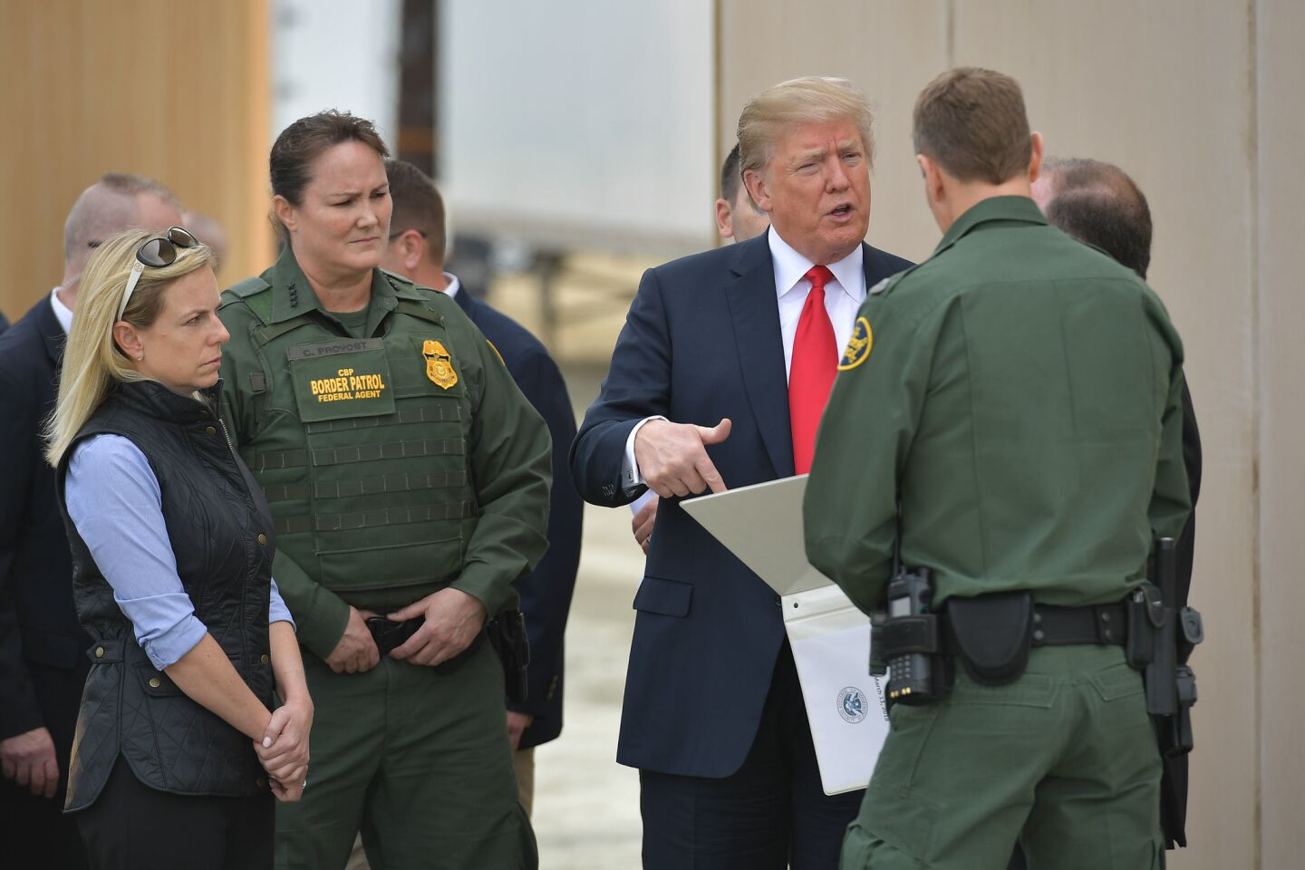President Trump asks questions about proposed border wall prototypes near San Diego on March 13.