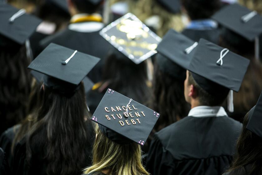 FILE - The cap of a University of Iowa graduates candidate is decorated with writing reading "Cancel student debt" during a commencement ceremony for the College of Liberal Arts and Sciences, Saturday, May 14, 2022, at Carver-Hawkeye Arena in Iowa City, Iowa. Massive tech layoffs, bank failures and a potential U.S. recession could throw a wrench in the plans of 2023 graduates — in the same year federal student loan payments are expected to resume and accrue interest. (Joseph Cress/Iowa City Press-Citizen via AP, File)