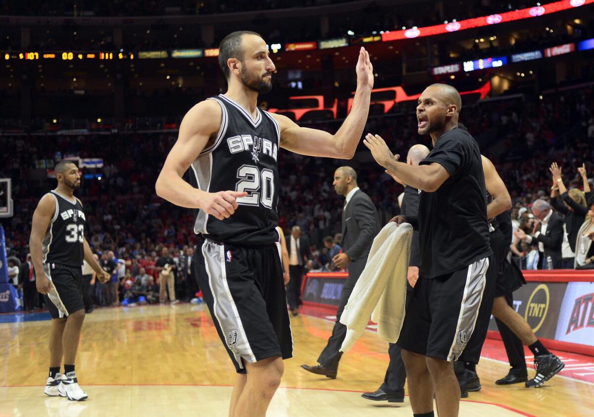 Guard Manu Ginobili is greeted by teammate Patty Mills during a timeout during the Spurs' Game 5 win over the Clippers at Staples Center.
