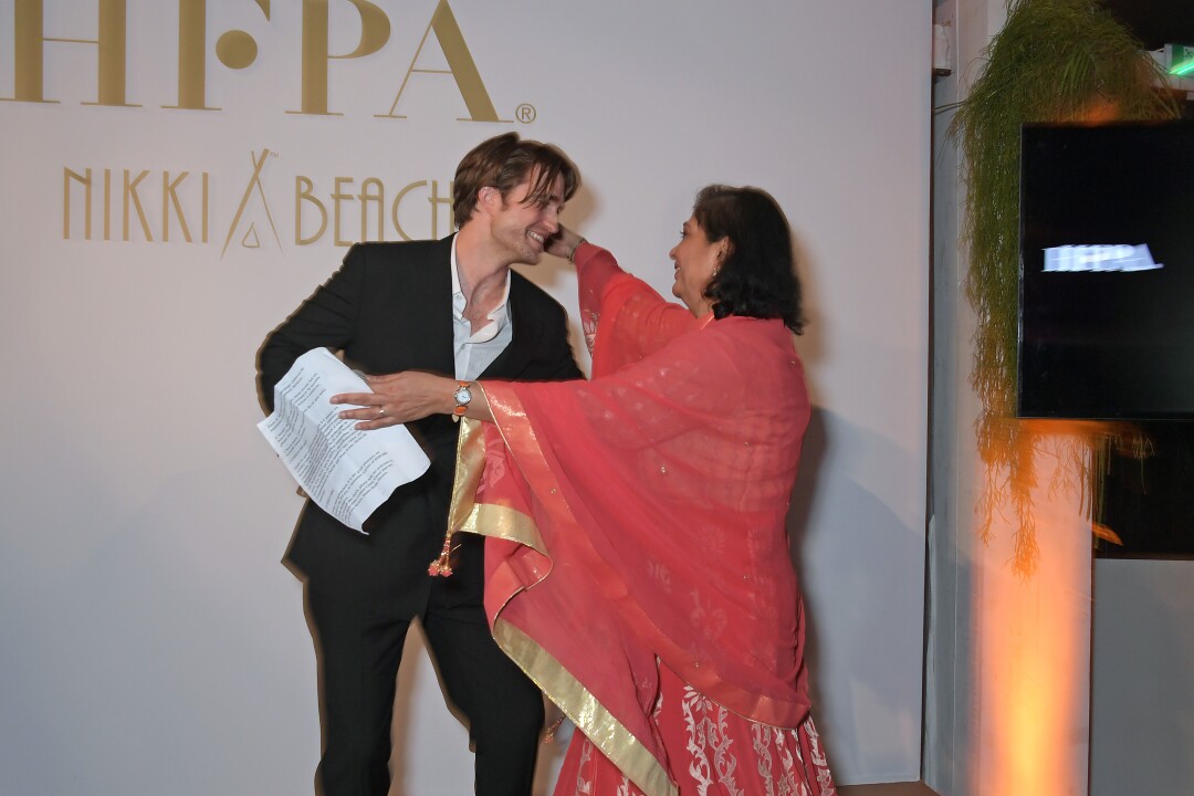 Robert Pattinson and former HFPA President Meher Tatna move in to hug each other