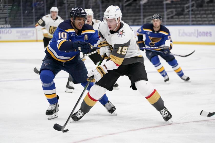 Vegas Golden Knights' Reilly Smith (19) controls the puck as St. Louis Blues' Brayden Schenn (10) defends during the third period of an NHL hockey game Monday, April 5, 2021, in St. Louis. (AP Photo/Jeff Roberson)